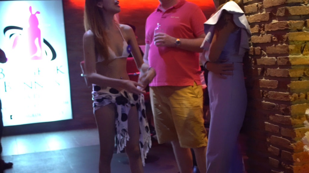 A sex worker chats outside a go-go bar in a Bangkok red light district. Photo Credit: Borderless News Online